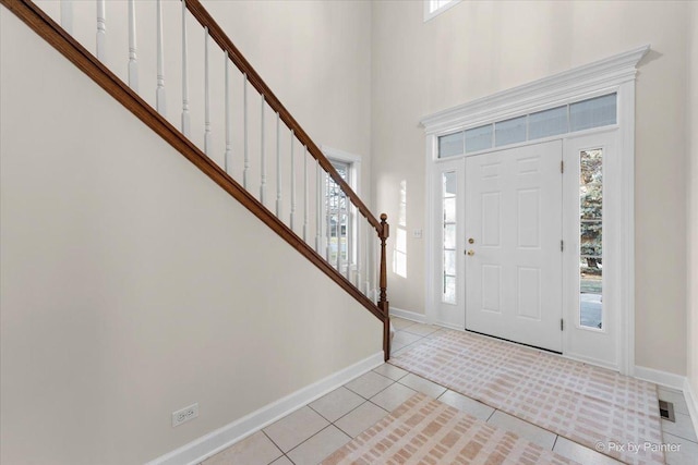 entrance foyer with a towering ceiling and light tile patterned floors