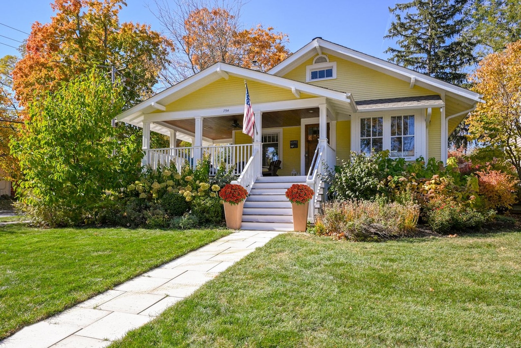 bungalow-style house with a front yard and covered porch