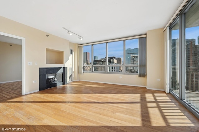 unfurnished living room featuring wood-type flooring and rail lighting