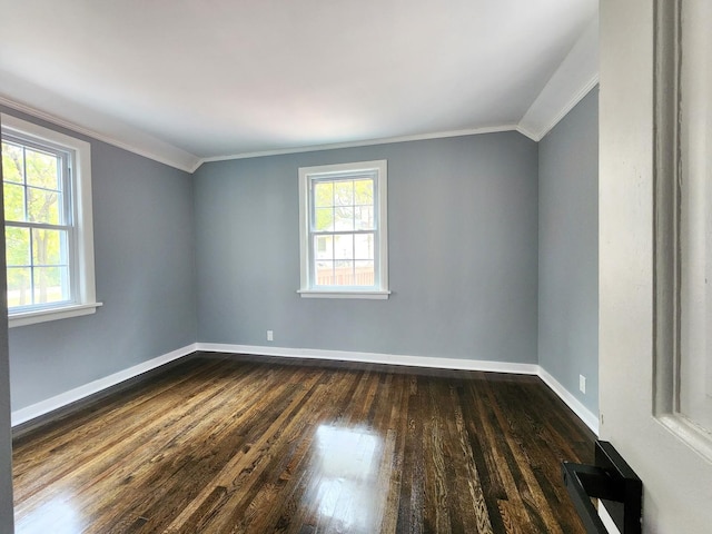 empty room with dark wood-type flooring, lofted ceiling, and ornamental molding