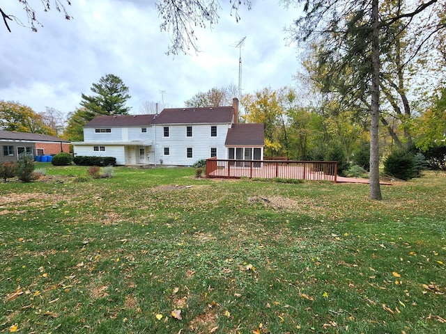 rear view of property with a deck and a yard