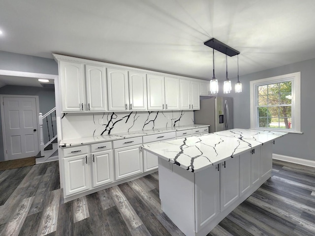 kitchen with white cabinets, decorative light fixtures, a center island, and stainless steel fridge with ice dispenser