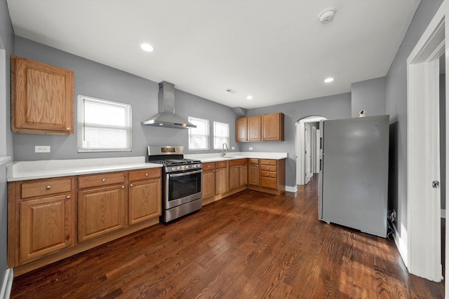 kitchen with sink, stainless steel appliances, dark hardwood / wood-style floors, and wall chimney range hood