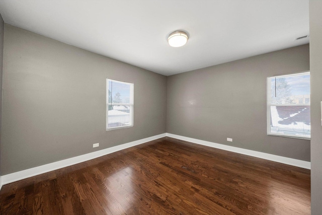 unfurnished room with dark wood-type flooring