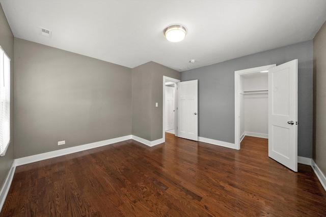 unfurnished bedroom featuring a closet and dark hardwood / wood-style floors