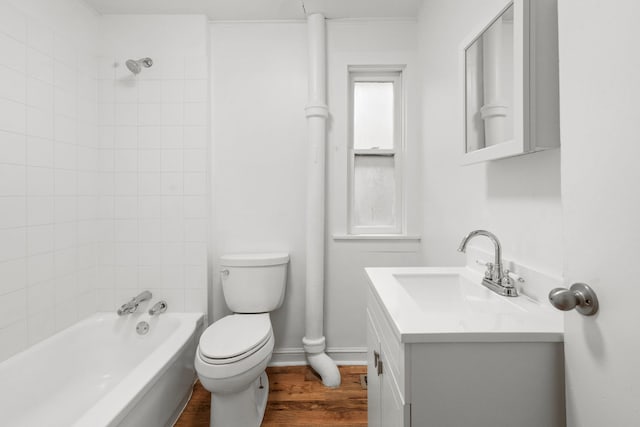 full bathroom with vanity, toilet, tiled shower / bath, and hardwood / wood-style flooring