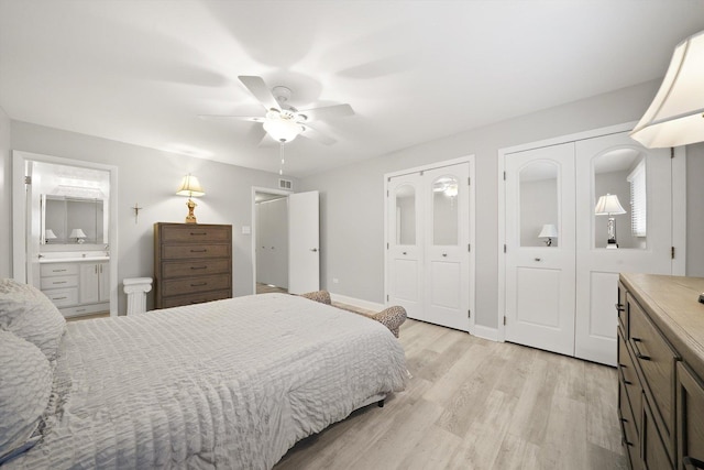 bedroom featuring multiple closets, ceiling fan, ensuite bathroom, and light wood-type flooring