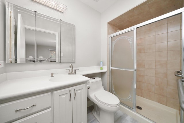 bathroom featuring vanity, an enclosed shower, and toilet