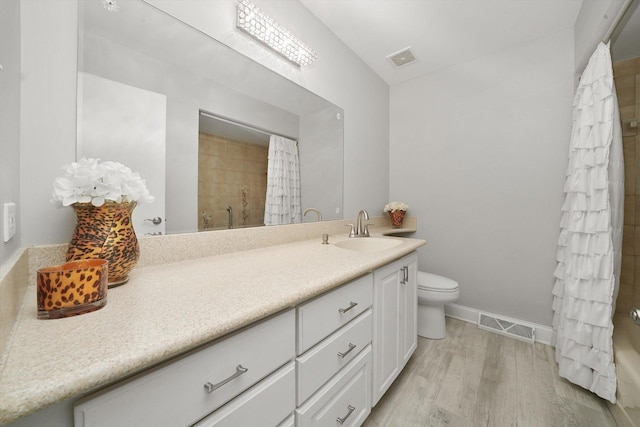 bathroom featuring curtained shower, hardwood / wood-style floors, vanity, and toilet