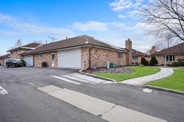 exterior space featuring cooling unit, a garage, and a front yard