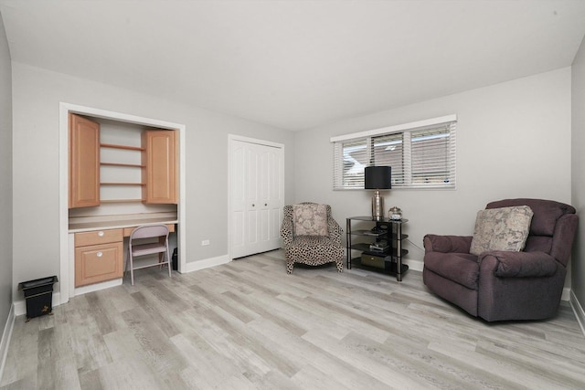 sitting room featuring built in desk and light hardwood / wood-style floors