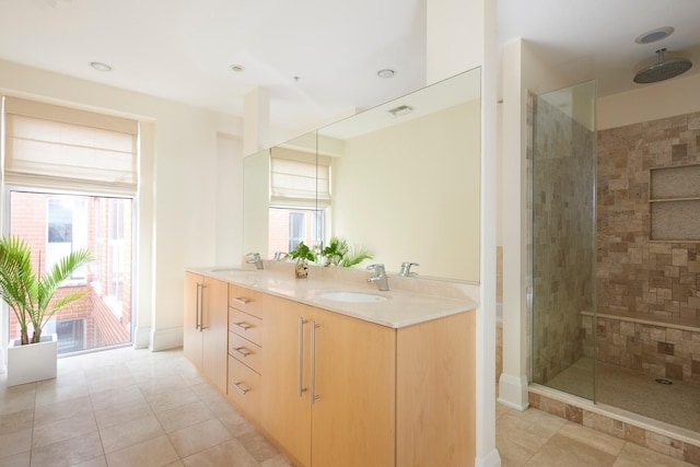 bathroom with tiled shower, vanity, and tile patterned floors