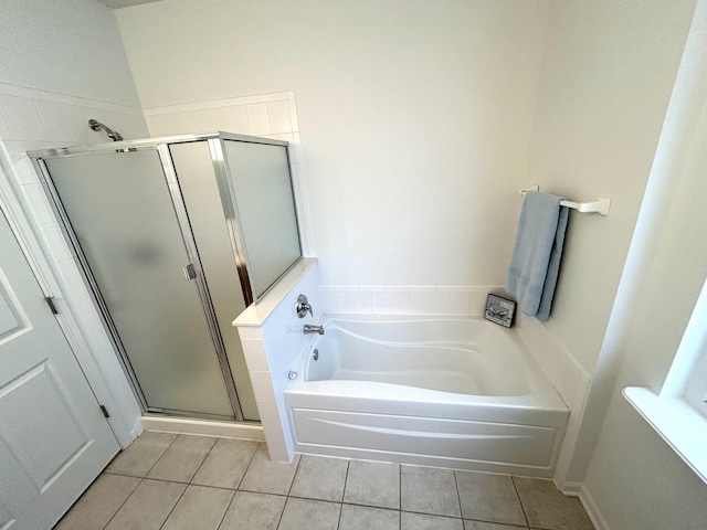 bathroom featuring tile patterned flooring, a stall shower, and a bath