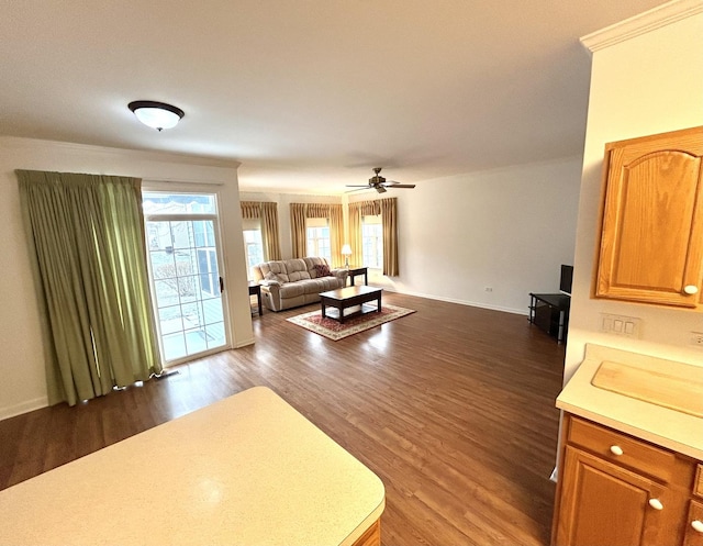 living room featuring baseboards, ceiling fan, and dark wood-style flooring