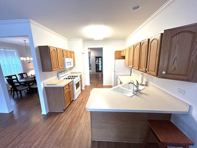 kitchen with a sink, white appliances, crown molding, light countertops, and a chandelier