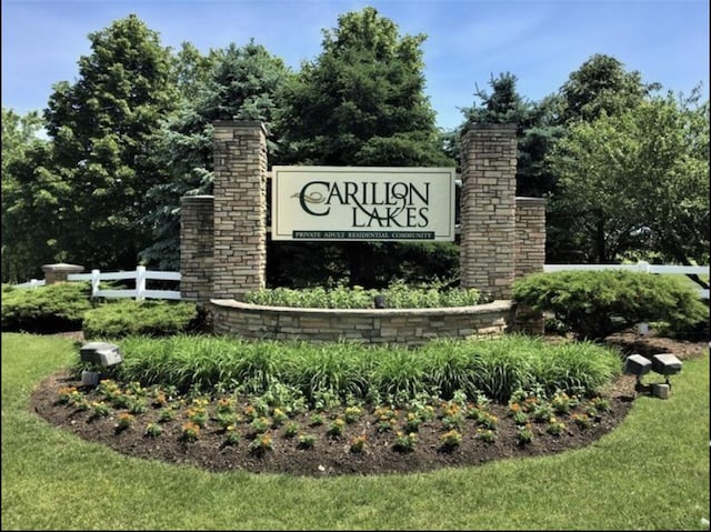 community / neighborhood sign featuring fence