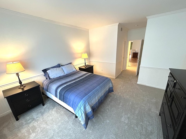 carpeted bedroom featuring a wainscoted wall and crown molding