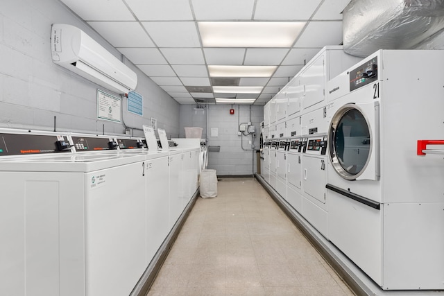 washroom featuring independent washer and dryer, a wall unit AC, and stacked washer / drying machine