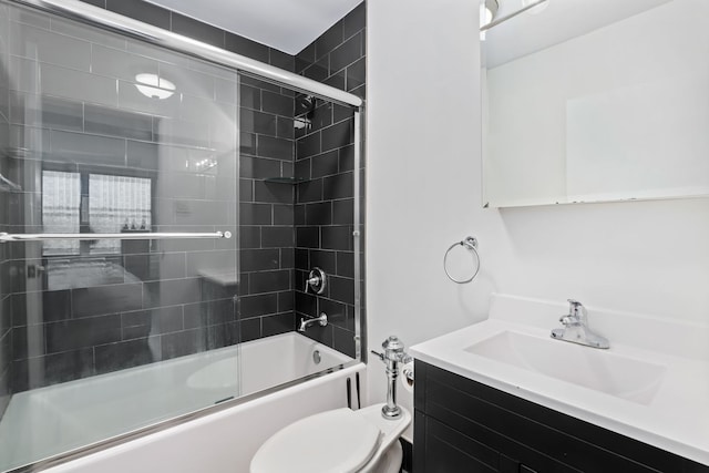 full bathroom with vanity, bath / shower combo with glass door, and toilet