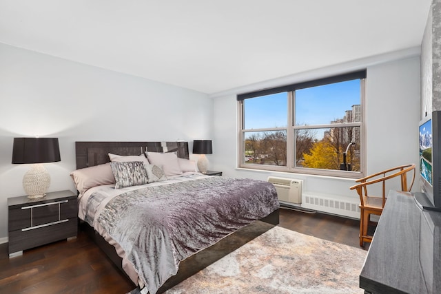 bedroom with a wall unit AC, dark wood-type flooring, and radiator