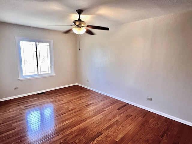 spare room featuring ceiling fan and dark hardwood / wood-style flooring