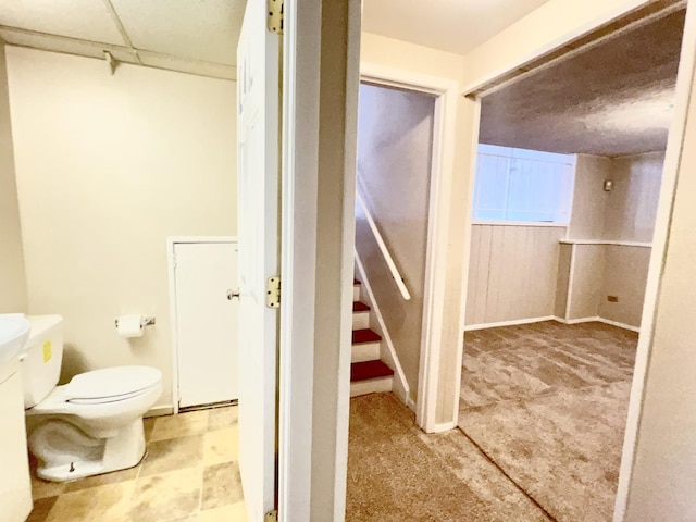 bathroom featuring toilet and wooden walls