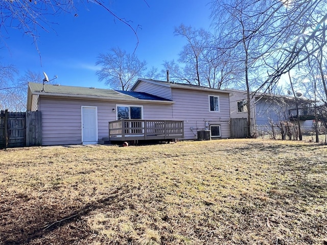 back of property featuring central AC unit, a deck, and a lawn