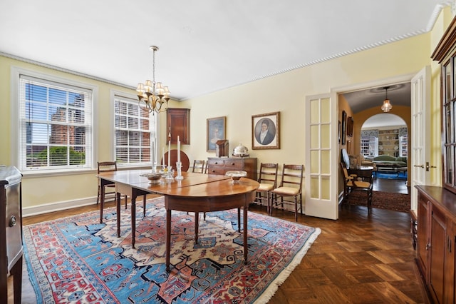 dining space featuring a chandelier, dark parquet flooring, and french doors