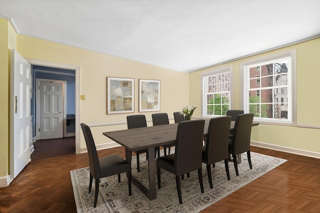 dining area with dark parquet floors and vaulted ceiling