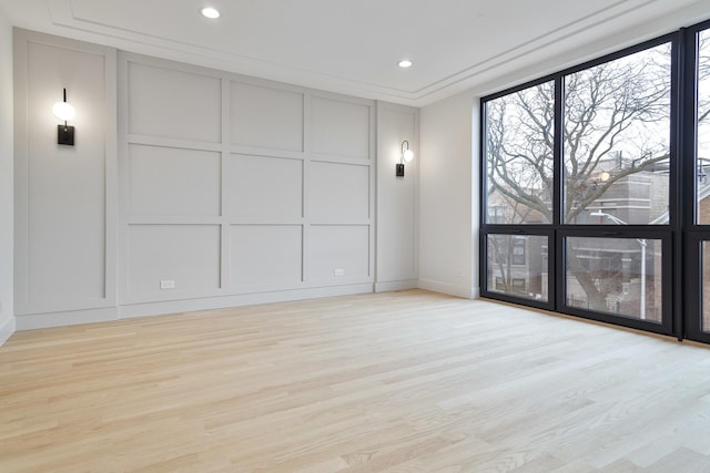 unfurnished room with light wood-type flooring and ornamental molding