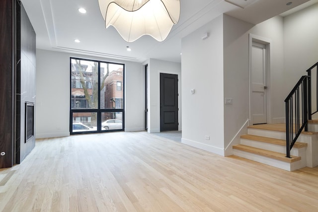 unfurnished living room featuring light hardwood / wood-style flooring and a wall of windows