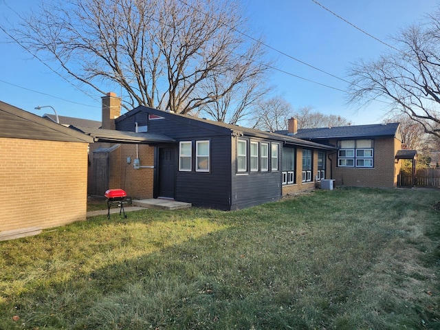 back of house with a yard and central AC unit