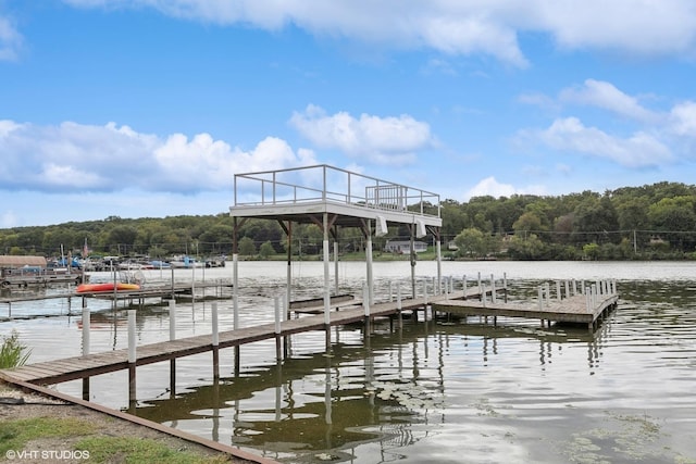 view of dock with a water view and a wooded view