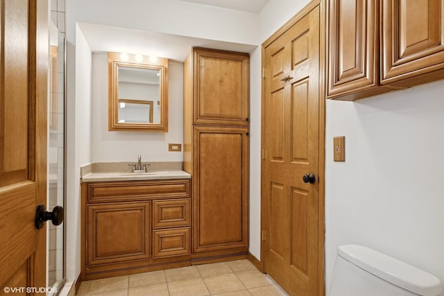 bathroom with toilet, tile patterned flooring, and vanity