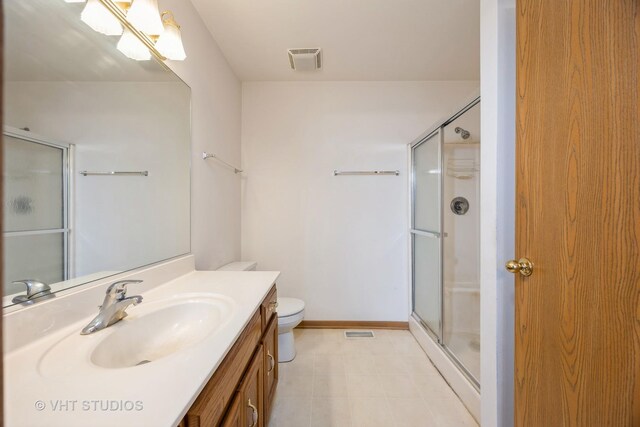 bathroom featuring vanity, toilet, and a shower with door