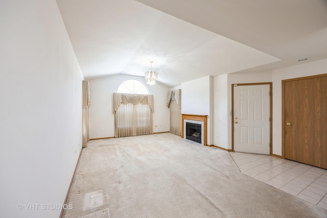 unfurnished living room featuring a chandelier, vaulted ceiling, and light tile patterned flooring