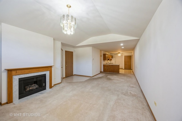 unfurnished living room featuring ceiling fan with notable chandelier, lofted ceiling, light carpet, and a high end fireplace