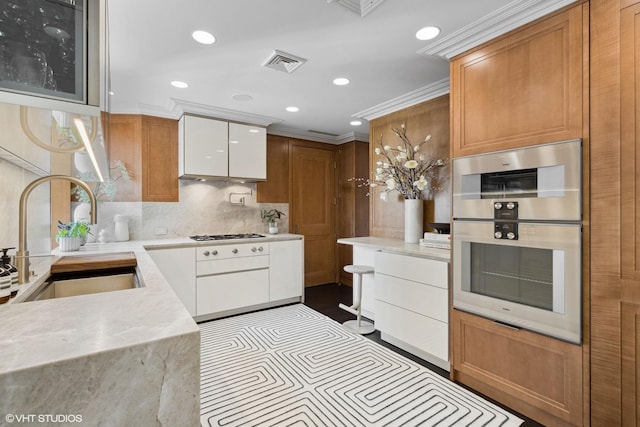1540 N Lake Shore Dr Unit 8N, Chicago, IL 60610 - kitchen featuring stainless steel double oven, decorative backsplash, recessed lighting, crown molding, and light stone countertops