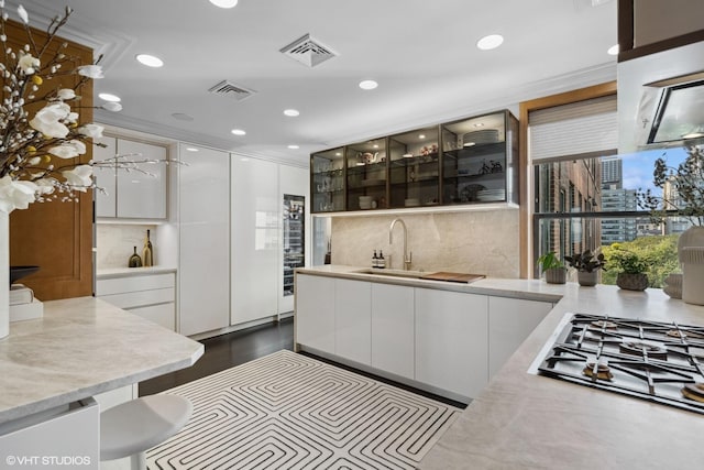 1540 N Lake Shore Dr Unit 8N, Chicago, IL 60610 - kitchen with modern cabinets, stainless steel gas cooktop, white cabinetry, backsplash, and recessed lighting