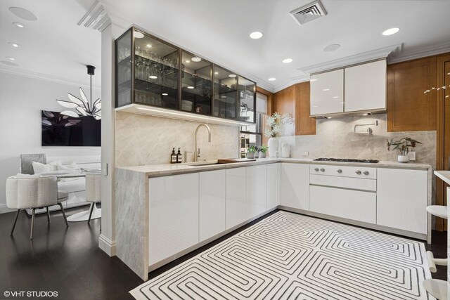 1540 N Lake Shore Dr Unit 8N, Chicago, IL 60610 - kitchen featuring ornamental molding, glass insert cabinets, light countertops, backsplash, and white cabinetry