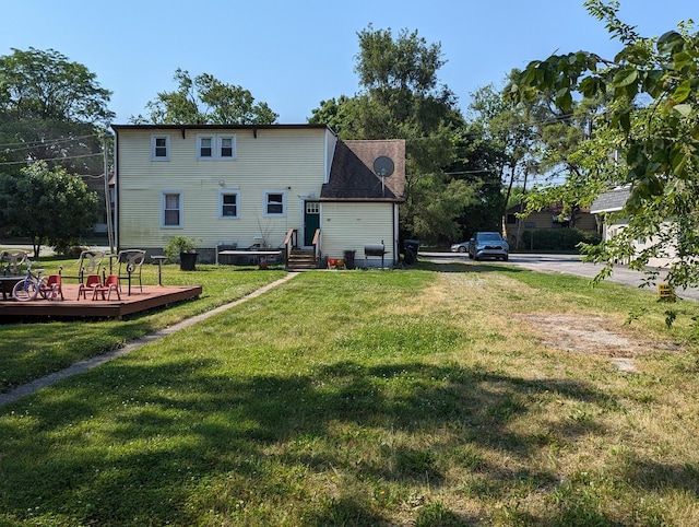 rear view of house with a lawn and a deck