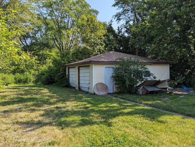 view of outdoor structure with a yard and a garage