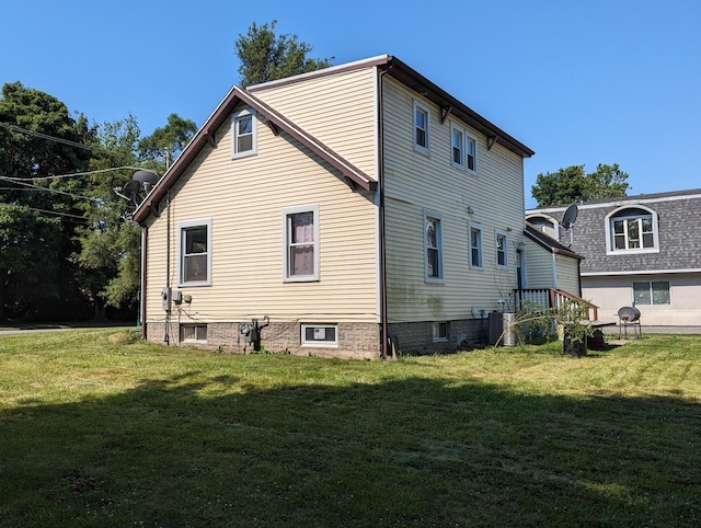 rear view of property with a yard and cooling unit