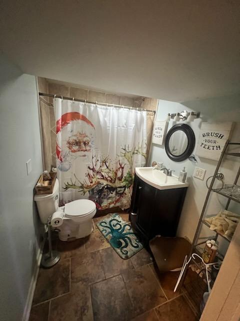 bathroom featuring toilet, vanity, and a shower with shower curtain