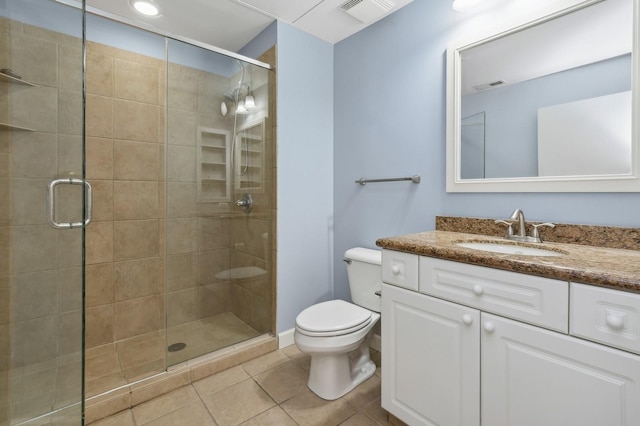 bathroom featuring tile patterned flooring, vanity, a shower with door, and toilet