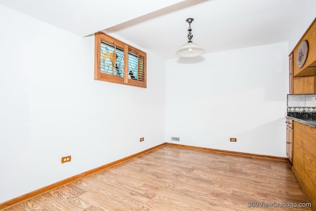 unfurnished dining area with light wood-type flooring