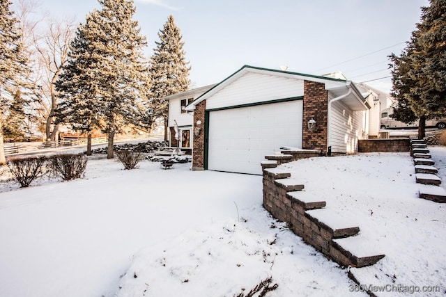 view of snowy exterior featuring a garage