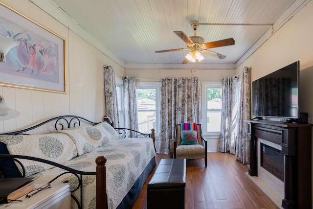 bedroom featuring light hardwood / wood-style floors, ceiling fan, crown molding, and wood ceiling