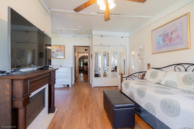 bedroom with light wood-type flooring, a closet, and ceiling fan