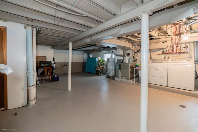 basement with heating unit, washing machine and clothes dryer, and water heater